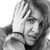 a black and white photo of a woman covering her face, transforming negative thoughts